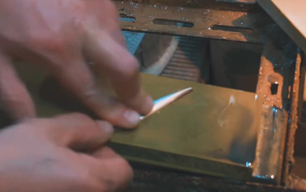 Afilando a mano tijeras en piedra profesional para lograr un filo extremadamente preciso y duradero.